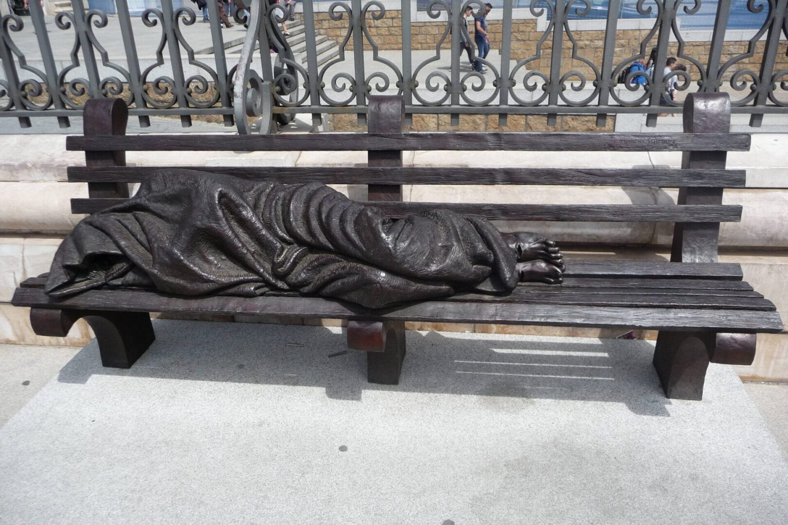 A statue of a person lying on a bench