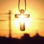A necklace with a cross illuminated by the sun