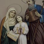 Father, mother, and daughter statue holding bibles