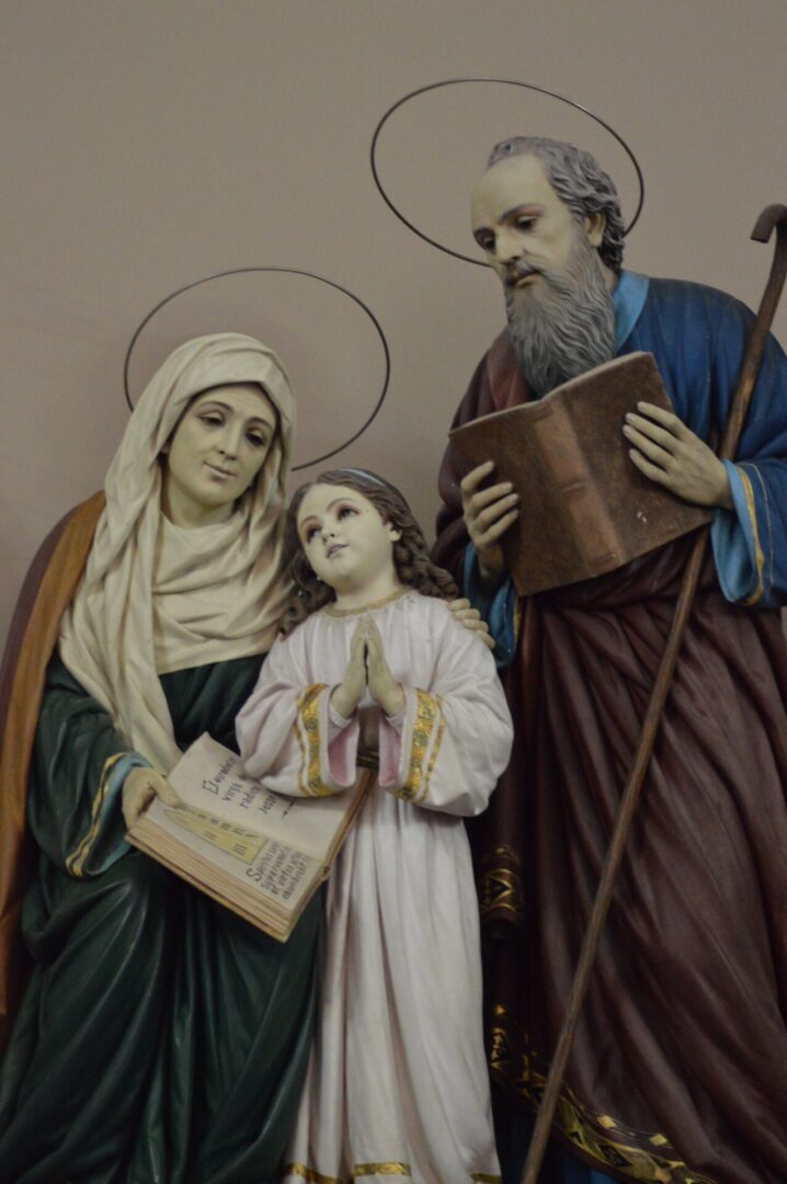 Father, mother, and daughter statue holding bibles