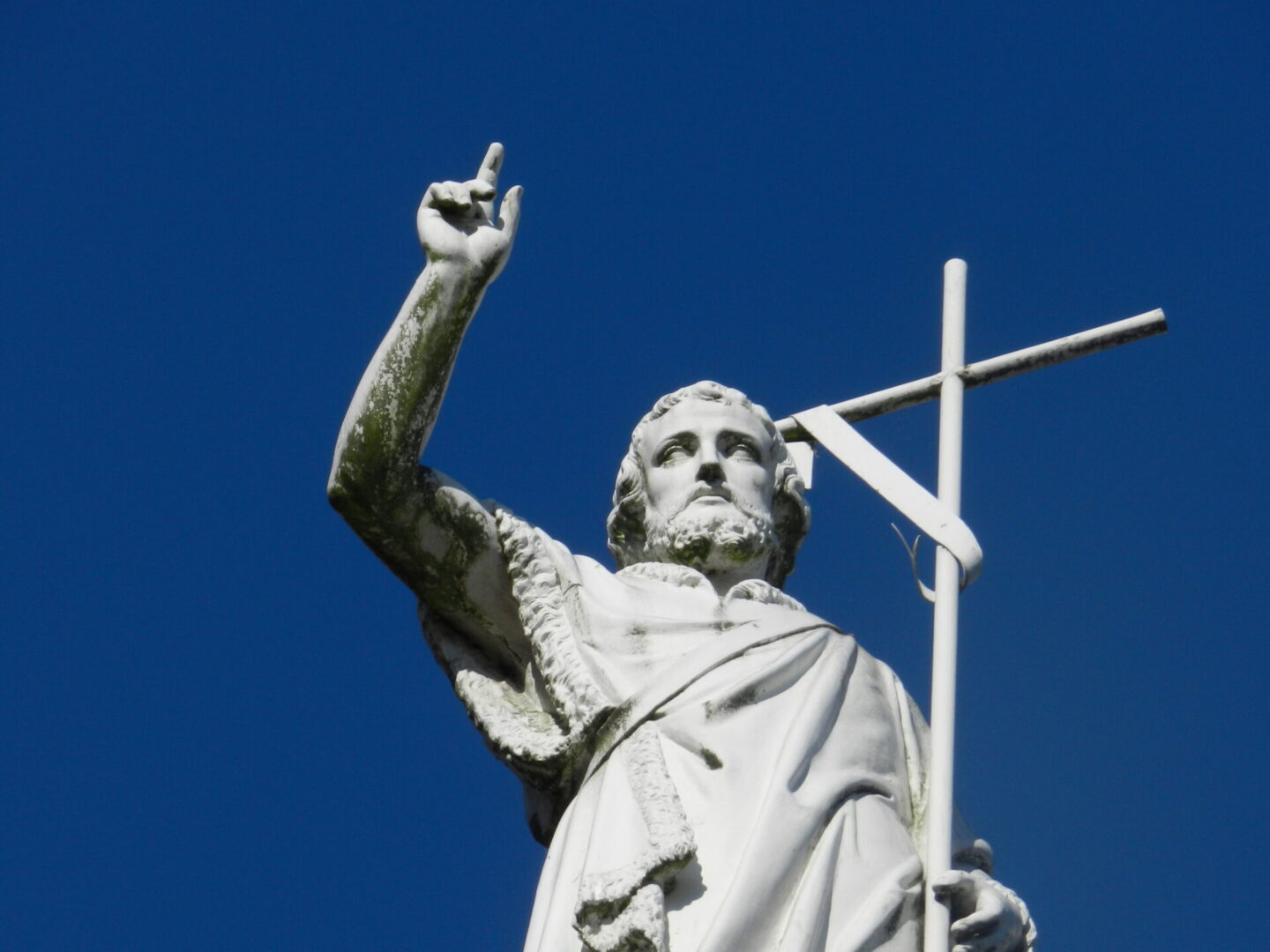 A white carnival statue of jesus holding a cross