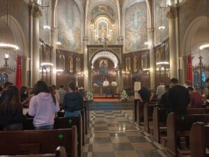 Inside view of church and group of people praying