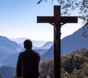 A man sitting next to the crucified statue