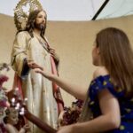 A Lady touching the hand of the jesus statue