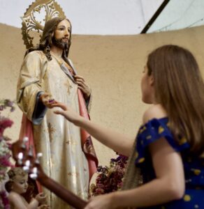 A Lady touching the hand of the jesus statue