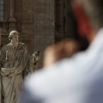 Closeup shot of a man looking at the white statue