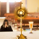 A woman praying in front of the eucharist monstrance