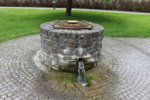 A closed well made of rocks with flowing water