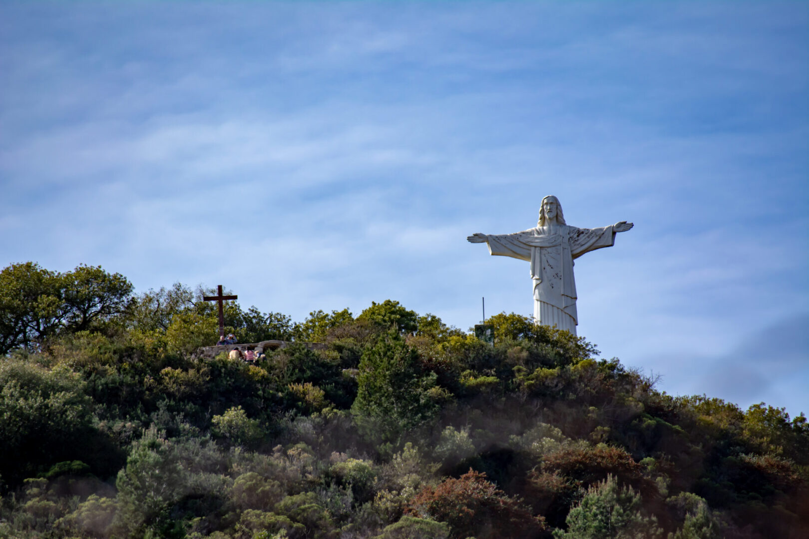 A view of jesus with open hands on the hill