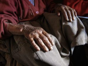 Close shot of an old woman hands on her knees