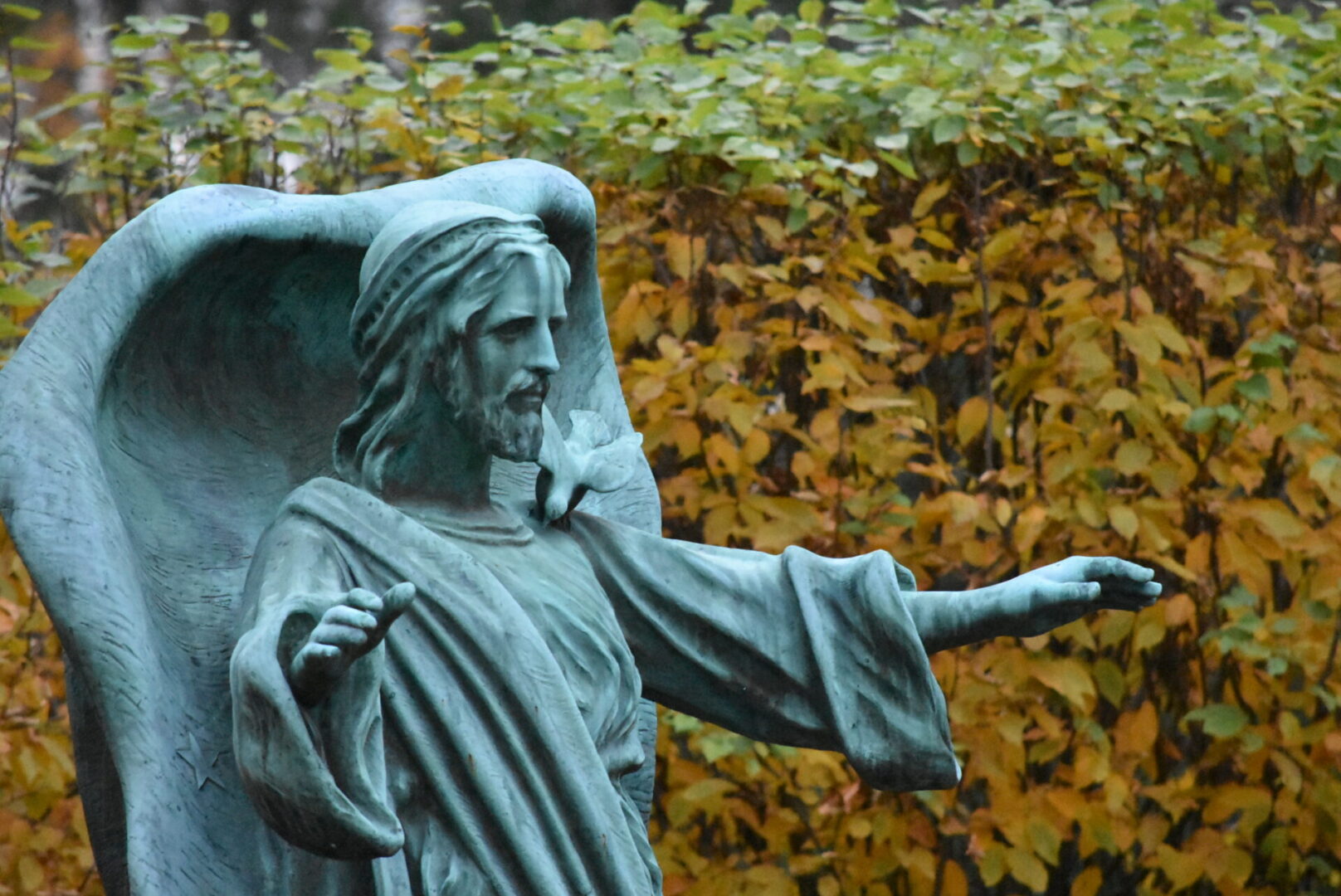 Statue of jesus with open hands in front of the rock