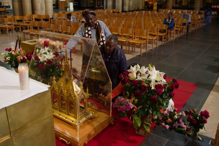 Catholics Praying at the Statue of Saint Theresa of the Child Jesus. 